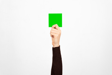 Hand of a business woman holding a green card in the air. Fault concept.