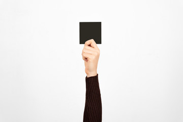 Hand of a business woman holding a black card in the air. Fault concept.