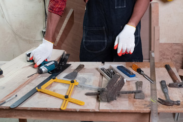 Hands tool of wood work plenty on desk,blurry light around