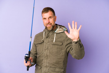 Senior fisherman isolated on purple background smiling cheerful showing number five with fingers.
