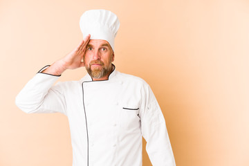 Chef man isolated on beige background being shocked, she has remembered important meeting.