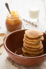 Fototapeta na wymiar Stacks of pancakes with strawberries on a white wooden background