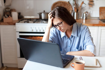 Upset woman working from home office. Unhappy freelancer using laptop and the Internet. Workplace...