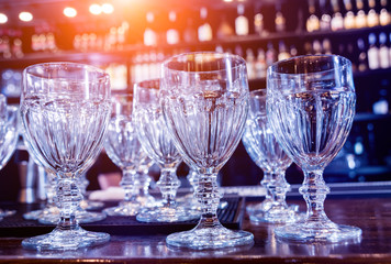 Wine and martini glasses in shelf above a bar rack in restaurant. 
