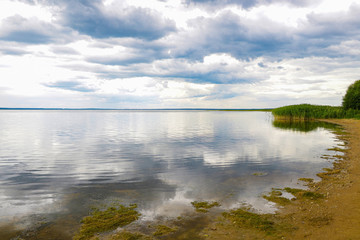 Shore of a large lake or sea on a cloudy day.