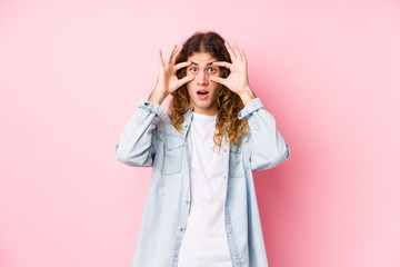 Long hair man posing isolated keeping eyes opened to find a success opportunity.