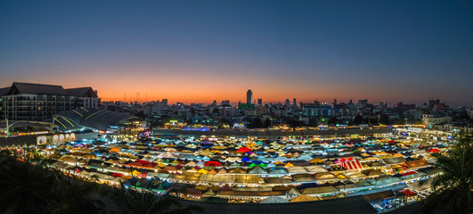 Panorama landscape view colorful of plastic roof of tent at ratchada train night market with sunset of bangkok city. popular place for shopping at night.