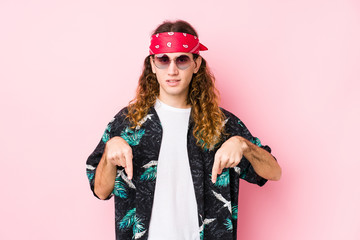 Young hippie caucasian man isolated points down with fingers, positive feeling.