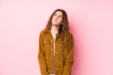 Young long hair man posing isolated dreaming of achieving goals and purposes