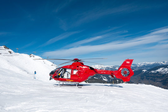red rescue helicopter stands on the snow-covered mountains of the Austrian Alps