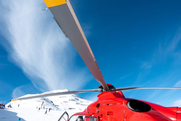 red rescue helicopter stands on the snow-covered mountains of the Austrian Alps