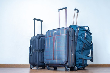 Three suitcases on the floor of the room. Luggage. Journeys. Excursions. Convenient devices for transporting things. Carry-on baggage. Baggage rules.