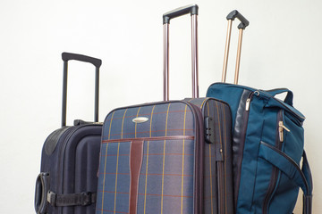 Three suitcases with pull-out handles close-up. Convenience for transporting personal items when traveling. Excursions. Necessary thing. Luggage.