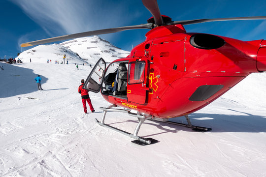 red rescue helicopter stands on the snow-covered mountains of the Austrian Alps