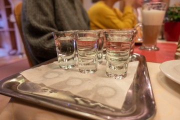a table there is a small tray with several small glasses of alcohol on it
