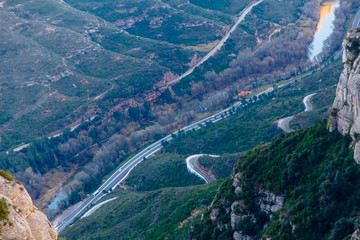 The road runs along the river between the mountains.