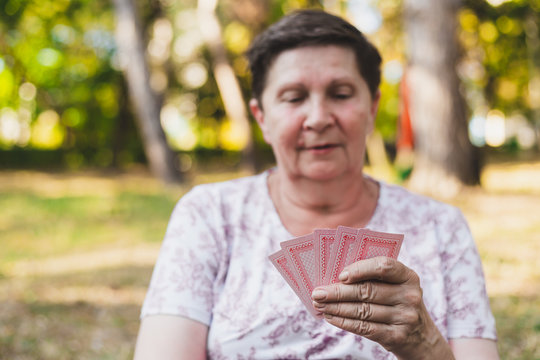 Old Woman Holding Five Playing Cards