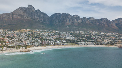aerial views of the coast of camps bay in south africa, next to cape town, lions head mountain and twelve apostles and all shore views