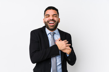 Young latin business woman against a white background isolated laughing keeping hands on heart, concept of happiness.