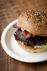 organic beef burger with bacon on wood table