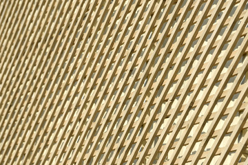 Wall of wooden planks. Lattice from a natural tree for weaving plants. Design for the decoration of buildings. Wood panel fence.