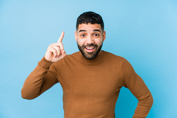 Young latin man against a blue  background isolated having an idea, inspiration concept.