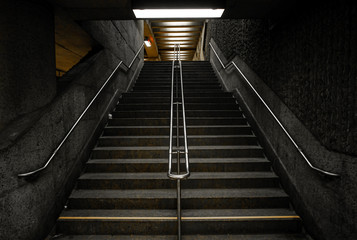 Dark Lit Concrete Staircases with a Middle Division with Handrails in Public Subway Station in Montreal, Quebec / Canada