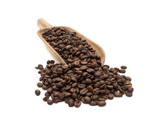 Roasted coffee beans on a large wood scoop in almost front view and isolated on white background