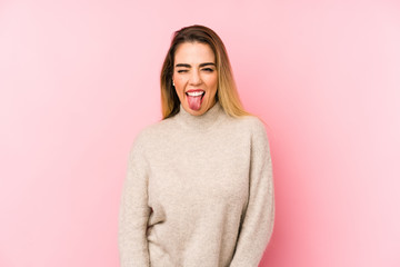 Fototapeta premium Middle age woman over isolated background funny and friendly sticking out tongue.