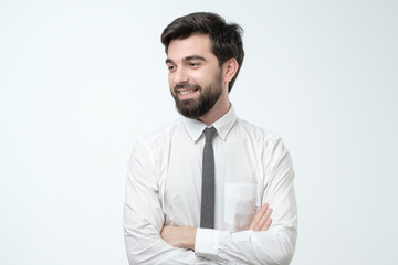 Hispanic young man standing with his arm crossed over white background