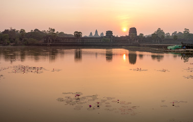 Fototapeta premium Sunrise view of popular tourist attraction ancient temple complex Angkor Wat with reflected in lake Siem Reap, Cambodia