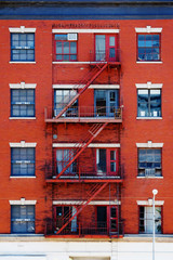 Escape fire ladders at beautiful colorful house facades in New York. Manhattan New York City -...