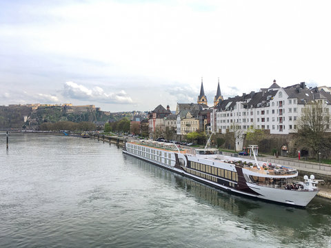 Luxurious rivercruise or river cruise ship on the Rhine for romantic and relaxing cruising on European rivers with Koblenz and fort in background