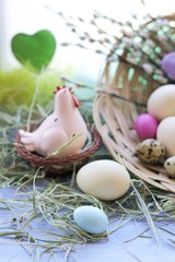 Happy Easter, a basket with painted eggs, a toy chicken, hay on the windowsill, interior decor for the holiday