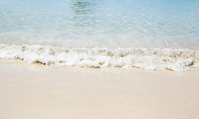 Fototapeta na wymiar Soft Wave Of Blue Ocean On Sandy Beach Background. Real photo in Thailand. Selective focus.