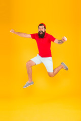 Fototapeta na wymiar Towards fun. Enjoying active lifestyle. Happy guy jumping. Active bearded man in motion yellow background. Active and energetic hipster. Energy charge. Healthy guy feeling good. Inspired concept
