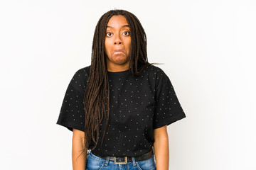 Young african american woman isolated on white background shrugs shoulders and open eyes confused.