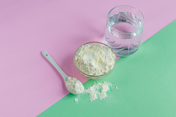 Collagen powder in a transparent bowl with a spoon for measuring quantity. Extra protein intake. Natural supplements for beauty and health. Collagen based plant concept. Flatlay, top view.