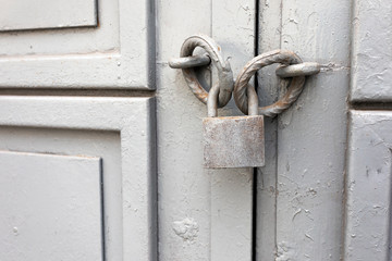 Old grey vintage lock on an iron door.
