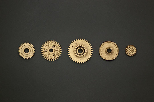 template of five golden gears on gray background