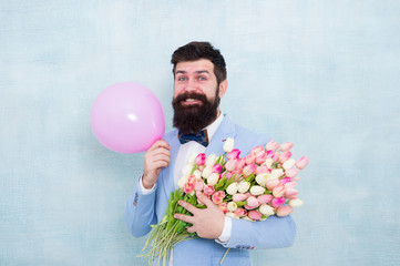 Birthday party. Bearded man hipster with flower bouquet. 8 march. Flowers for womens day. Bearded man with tulips. Spring mood. Love date. Gift bouquet. Present for spouse. Guy with air balloon