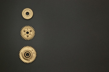 template of three golden gears on gray background