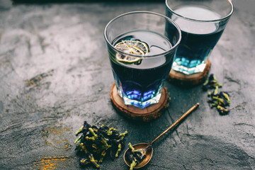 Butterfly pea flower blue tea. Detox drinking on dark table. Healthy herbal drink. Blue herbal tea anchan with lime