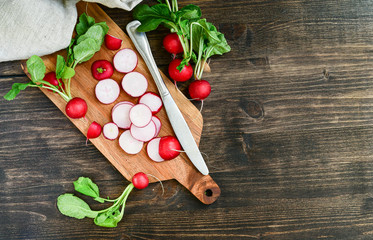 radish vitamin salad, sliced fresh radish on wooden Board. salad recipe with seasonal vegetables,...