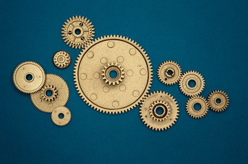 pile of golden gears on blue background