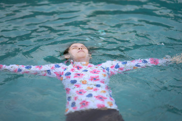 Woman folats on water in sea in freedom travel beach concept