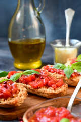 classic starter in an Italian restaurant: crostini (toasted bread) with tomatoes, olive oil, basil and parmesan. the bruschetta recipe. traditional lunch and dinner food  in Italy Rome Milan Florence