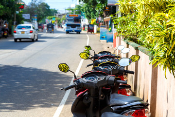 motorcycle Parking on the street of the island of Sri Lanka, street and traffic on it, Asia, Ceylon. Depth of field, focus blur