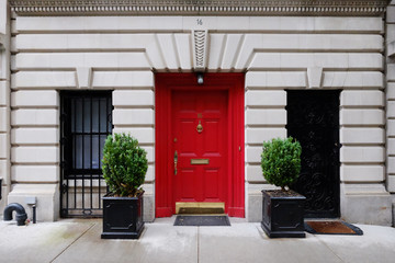 Beautiful building. Entrance red door, Manhattan New York, USA. Classic apartment estate in New...