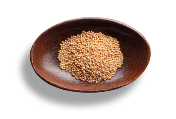 Senfkörner in einer Holzschale isoliert auf weiss